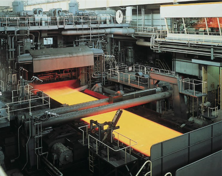 Red-hot steel is rolled into strip by industrial machine and cooled by water