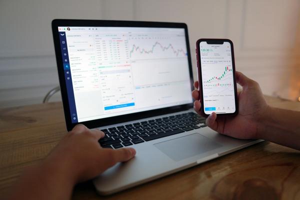 Stock foto of a laptop and mobile phone showing the stock market